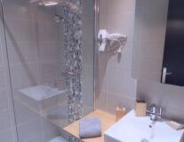 a glass shower door next to a sink